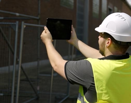 Construction worker using AR on a tablet on-site